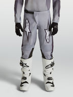 Alpinestars 2027 Fluid Amber ungdomsbyxor, gråa och svarta motocrossbyxor, slitstarkt 600D-polytyg, ergonomisk design för unga förare vid terrängkörning.