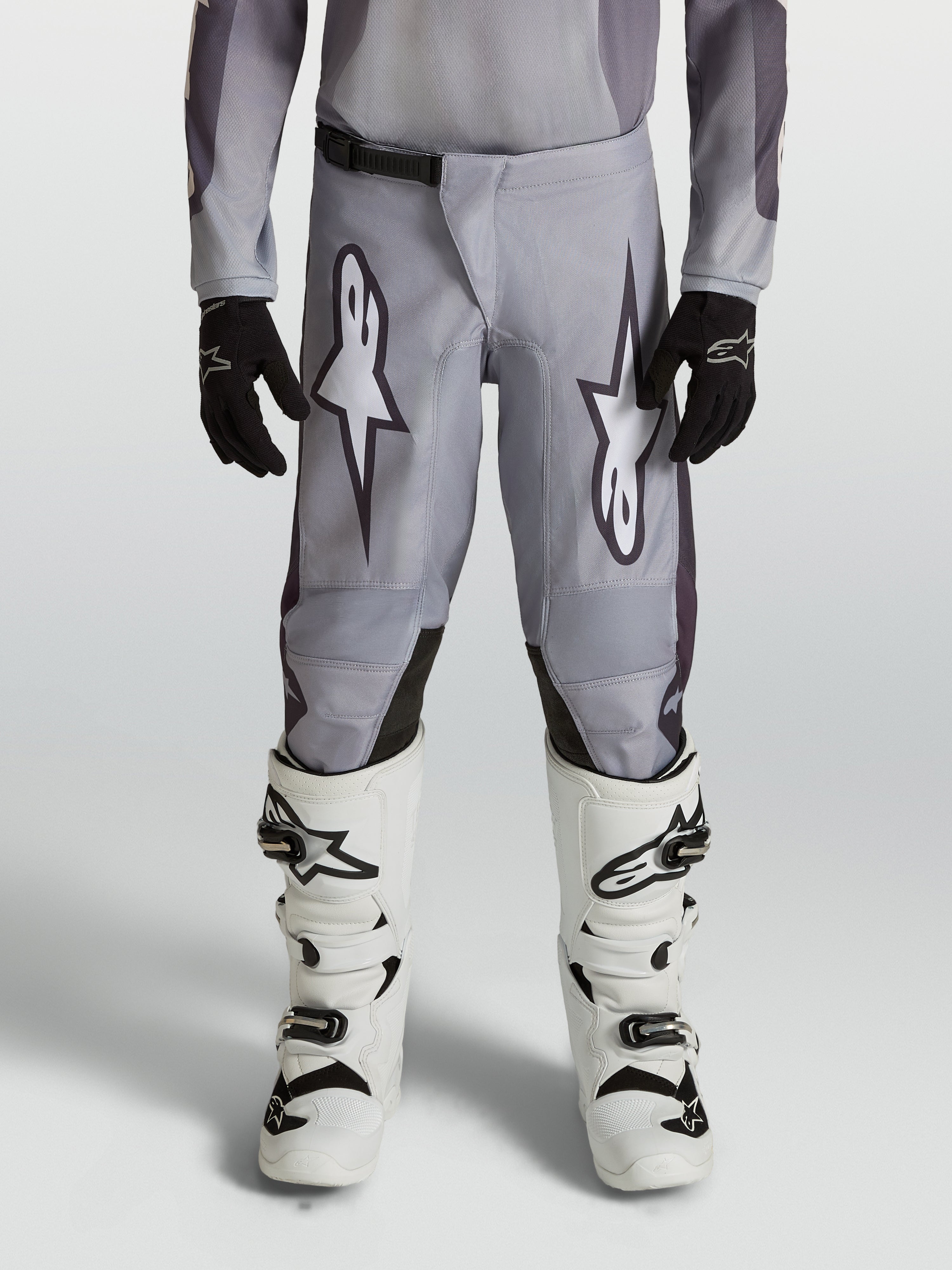Alpinestars 2027 Fluid Amber ungdomsbyxor, gråa och svarta motocrossbyxor, slitstarkt 600D-polytyg, ergonomisk design för unga förare vid terrängkörning.