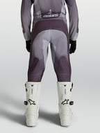 Alpinestars 2027 Fluid Amber motocrossbyxor för ungdom, grå och sand, förstärkt säte och stretchpaneler, bakifrån på modell.