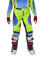 Alpinestars Youth 2024 Racer Hoen byxor, motocrossbyxor för ungdomar, neongul och mörkblå (Blue Night Navy), med röda stjärnlogotyper på låren, bärs med matchande tröja, röda och svarta handskar samt vita, svarta och röda motocross-stövlar, hållbar utrustning för terrängkörning