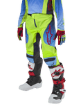 Alpinestars Youth 2024 Racer Hoen Pants, motocrossbyxor för ungdomar, neongula och marinblå med röda detaljer, bärs med matchande handskar och stövlar i vitt, svart och rött, sportig passform och förböjda ben för terrängkörning
