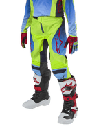Alpinestars Youth 2024 Racer Hoen Pants, motocrossbyxor för ungdomar, neongula och marinblå med röda detaljer, bärs med matchande handskar och stövlar i vitt, svart och rött, sportig passform och förböjda ben för terrängkörning