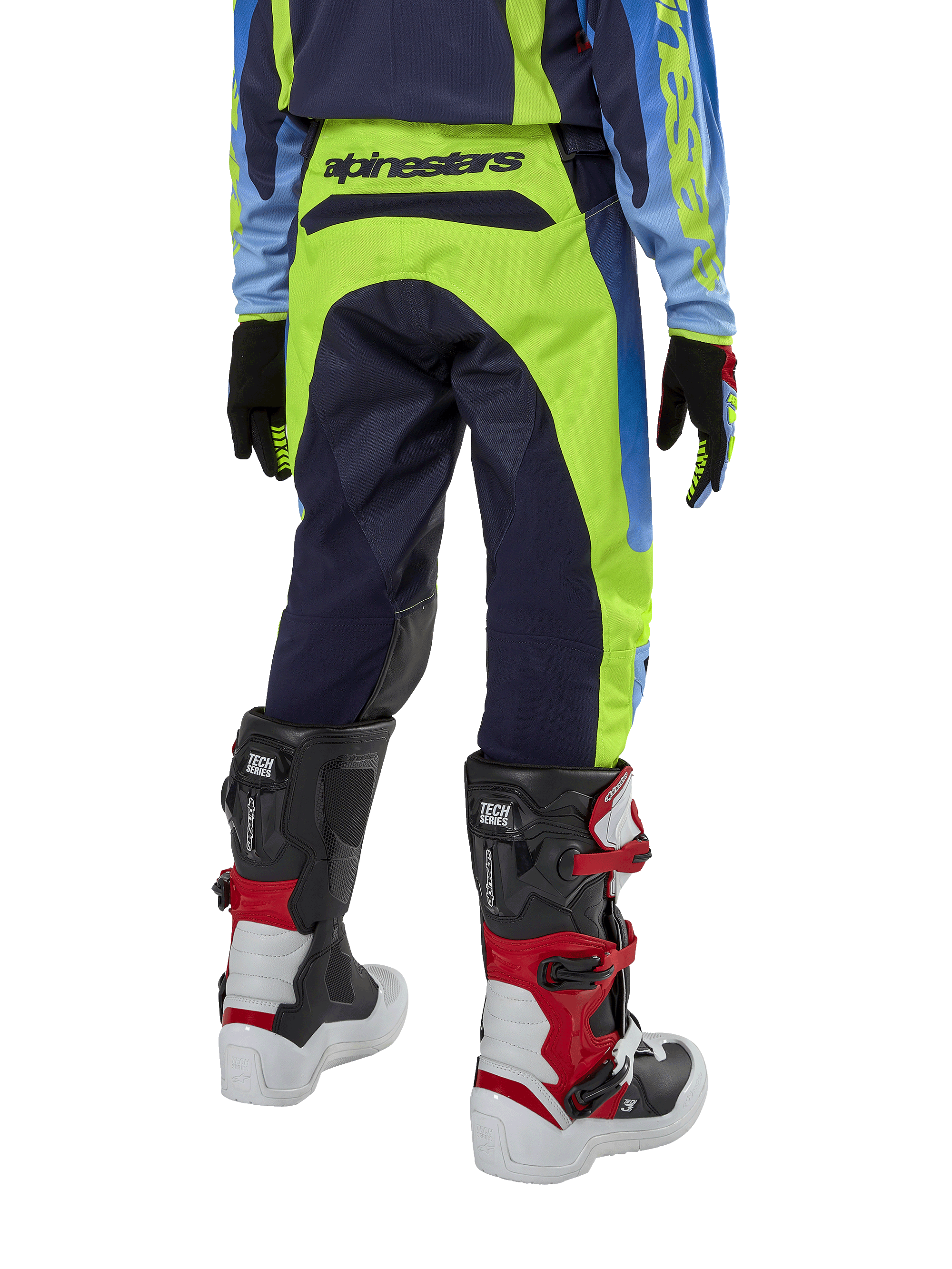 Alpinestars Youth 2024 Racer Hoen byxor, motocrossbyxor, gul fluo och mörkblå (Blue Night Navy), vy bakifrån som visar tydlig Alpinestars-logotyp på linningen, bärs med svarta och röda Tech Series-stövlar och matchande tröja, hållbar sportpassform för terrängkörning för ungdomar