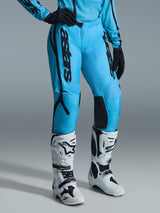 Alpinestars 2026 Woman Stella Fluid Apex Pants, Motocross Pants, Bright Blue with Black branding, worn with matching jersey, black gloves, and white and black off-road boots, ergonomic design for performance riding
