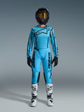 Alpinestars 2026 Stella Fluid Apex utrustningsset, motocrosströja och byxor för dam, blå och svart, med stor stjärnlogotyp på bröstet, bärs med svart hjälm, tonade goggles och vita stövlar med svarta detaljer, komplett outfit för offroadracing