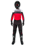 Motocrossförare som bär Alpinestars Pro-Dura Jersey i svart, klarrött och vitt, tillsammans med svarta byxor, svarta stövlar och en svart hjälm, komplett racingutrustning för terrängkörning.