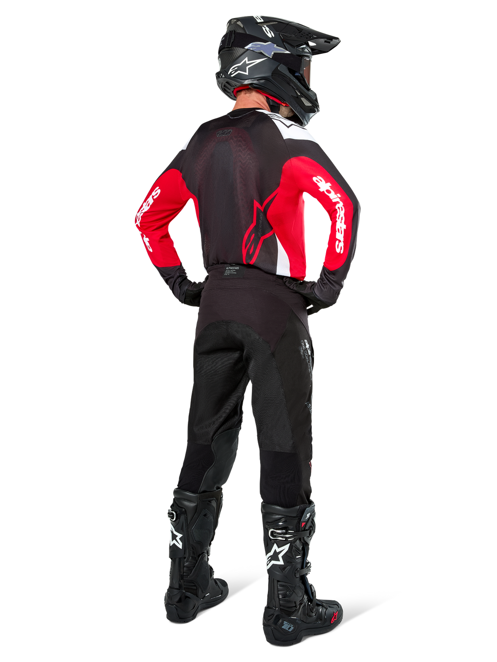 Motocrossförare sedd bakifrån klädd i Alpinestars Pro-Dura-tröja i svart, rött och vitt, matchad med svarta motocrossbyxor, hjälm och stövlar, visar ryggdesignen och ärmlogotyperna, koordinerad utrustning för terrängkörning.