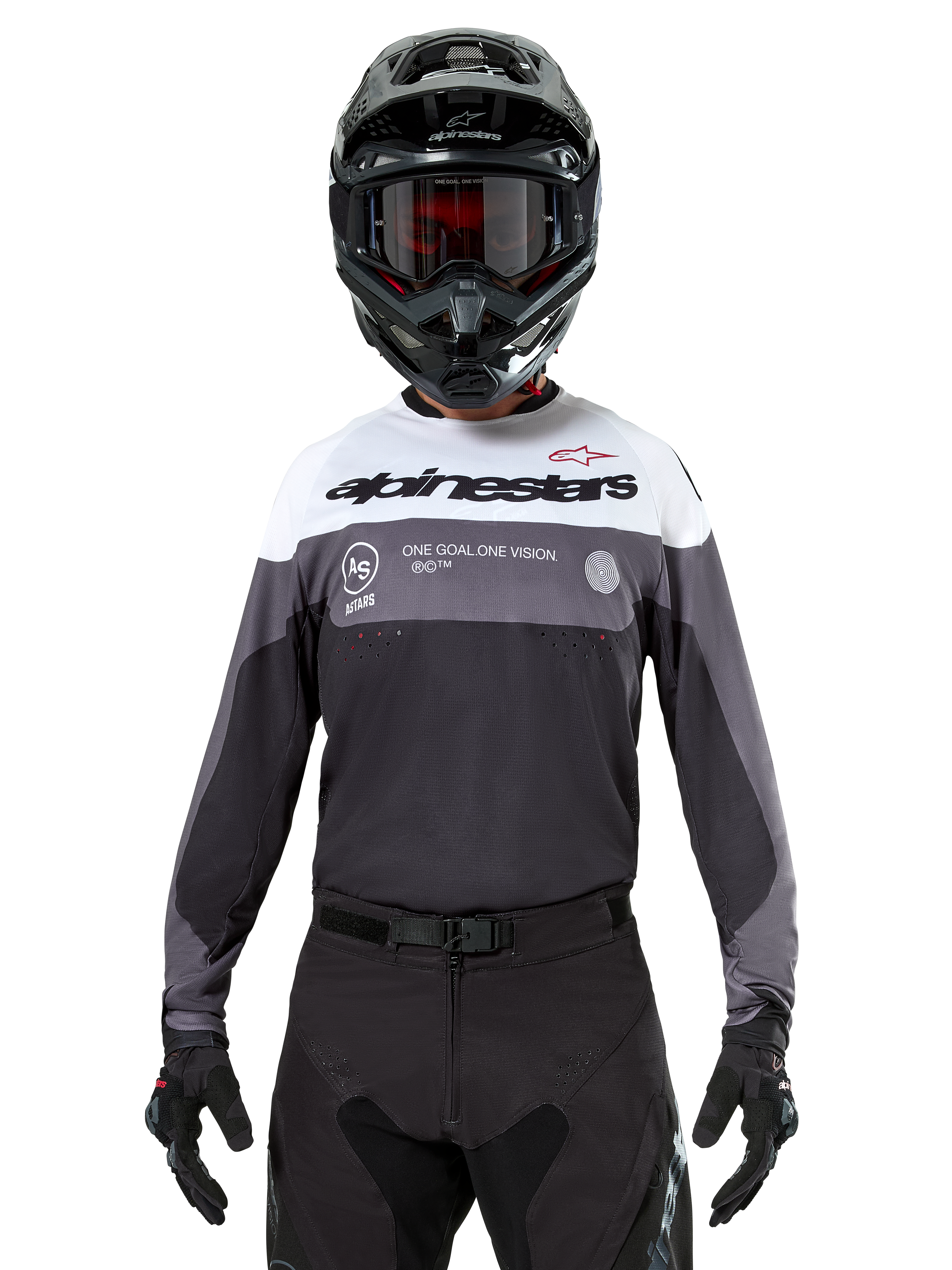 Motocrossförare som bär Alpinestars Pro-Dura Jersey i Black Magnet White, långärmad funktionströja med vita och grå färgblock, svart hjälm och goggles, 'alpinestars'-branding och slogan 'ONE GOAL ONE VISION', offroad-racingkläder