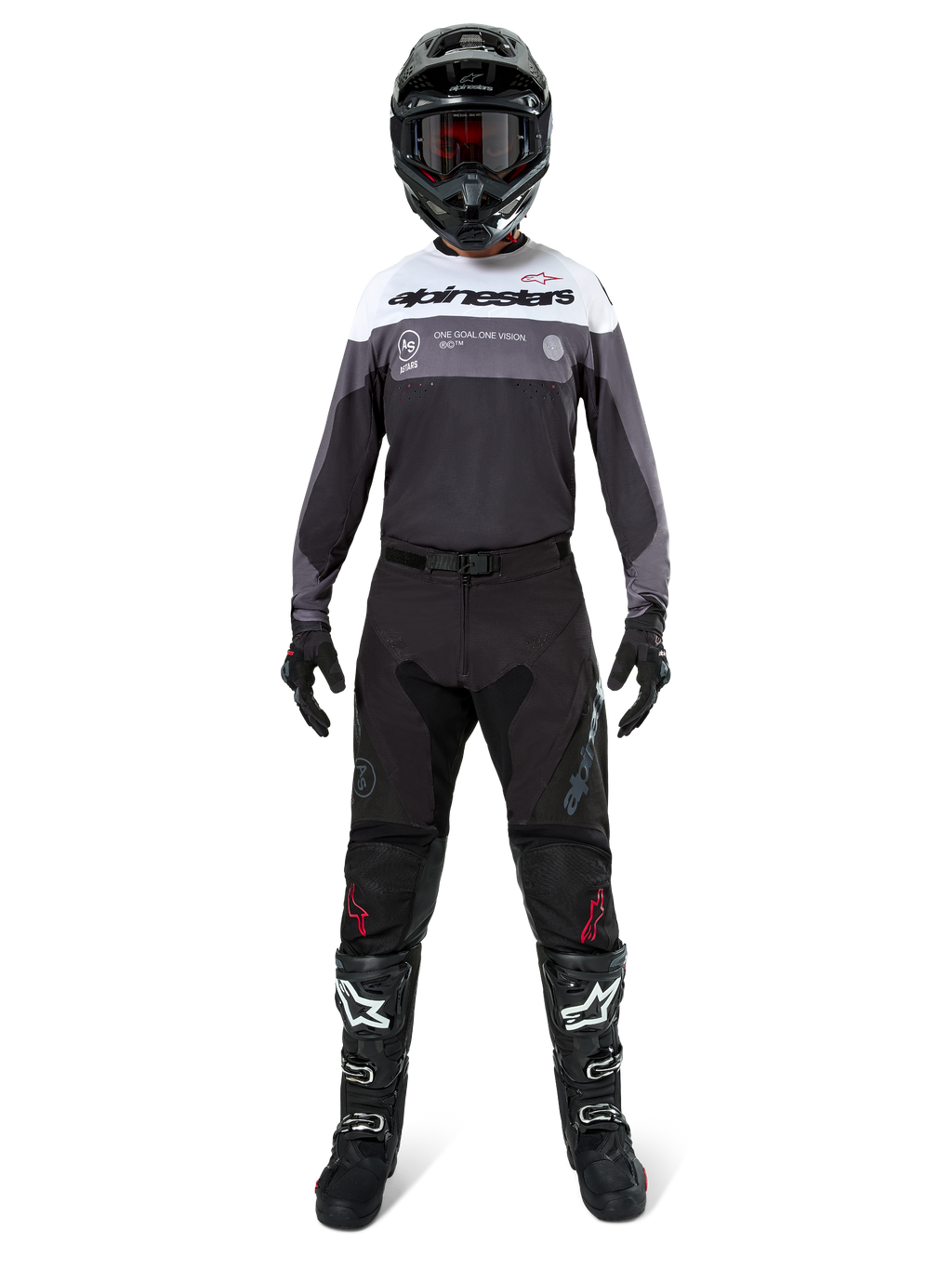 Motocrossförare i komplett racingutrustning, Pro-Dura Jersey i Black Magnet White med vitt övre bröstparti och grå detaljer, matchad med svarta byxor, svart hjälm med mörka goggles, vita och svarta stövlar och svarta handskar, koordinerad outfit för enduro och terrängkörning