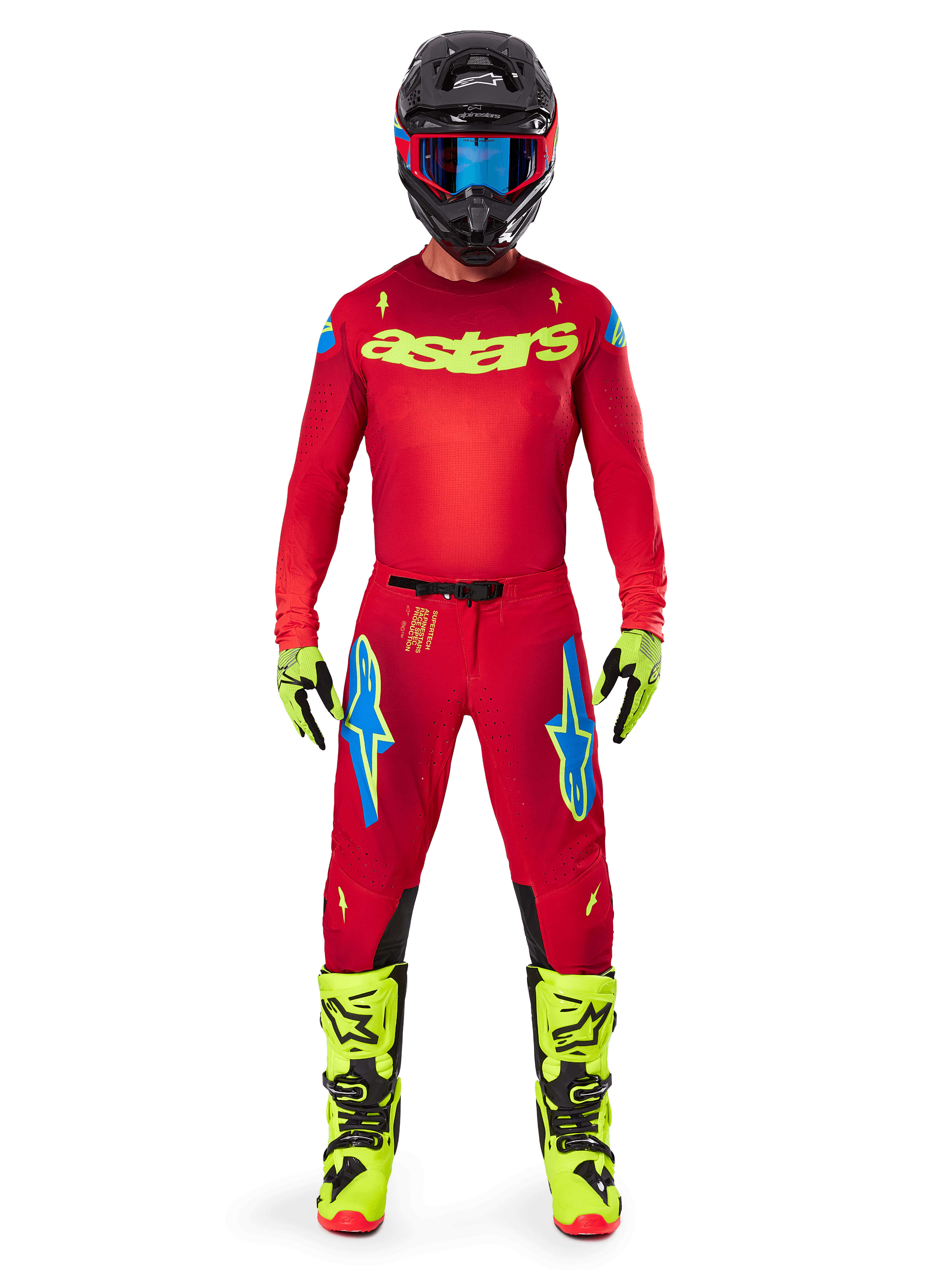 Motocross rider wearing complete Alpinestars 2025 Supertech Maker Gear Set, Bright Red jersey with yellow fluo 'astars' branding, matching red pants with blue accents, black helmet with blue goggles, bright yellow fluo boots and gloves, coordinated outfit for off-road racing