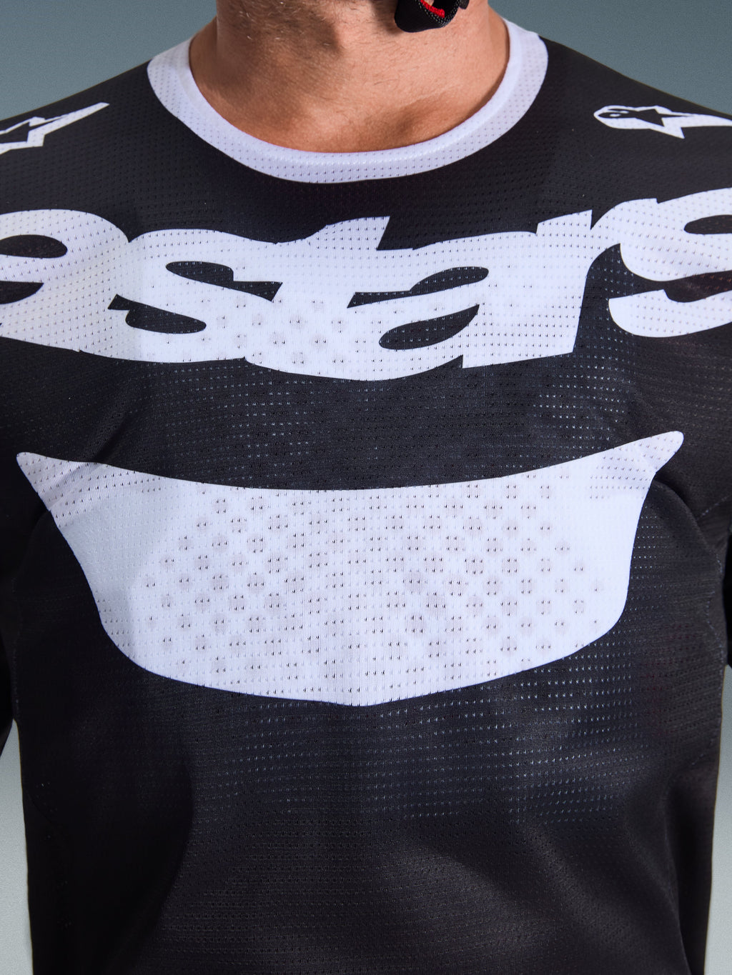 Alpinestars 2026 Racer Air Riway-tröja, motocrosströja, svart och vit, närbild av bröstet med stor vit logotyp, detaljerad meshtextur för luftflöde, teknisk utrustning med andasfunktion för terrängkörning