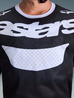 Alpinestars 2026 Racer Air Riway-tröja, motocrosströja, svart och vit, närbild av bröstet med stor vit logotyp, detaljerad meshtextur för luftflöde, teknisk utrustning med andasfunktion för terrängkörning