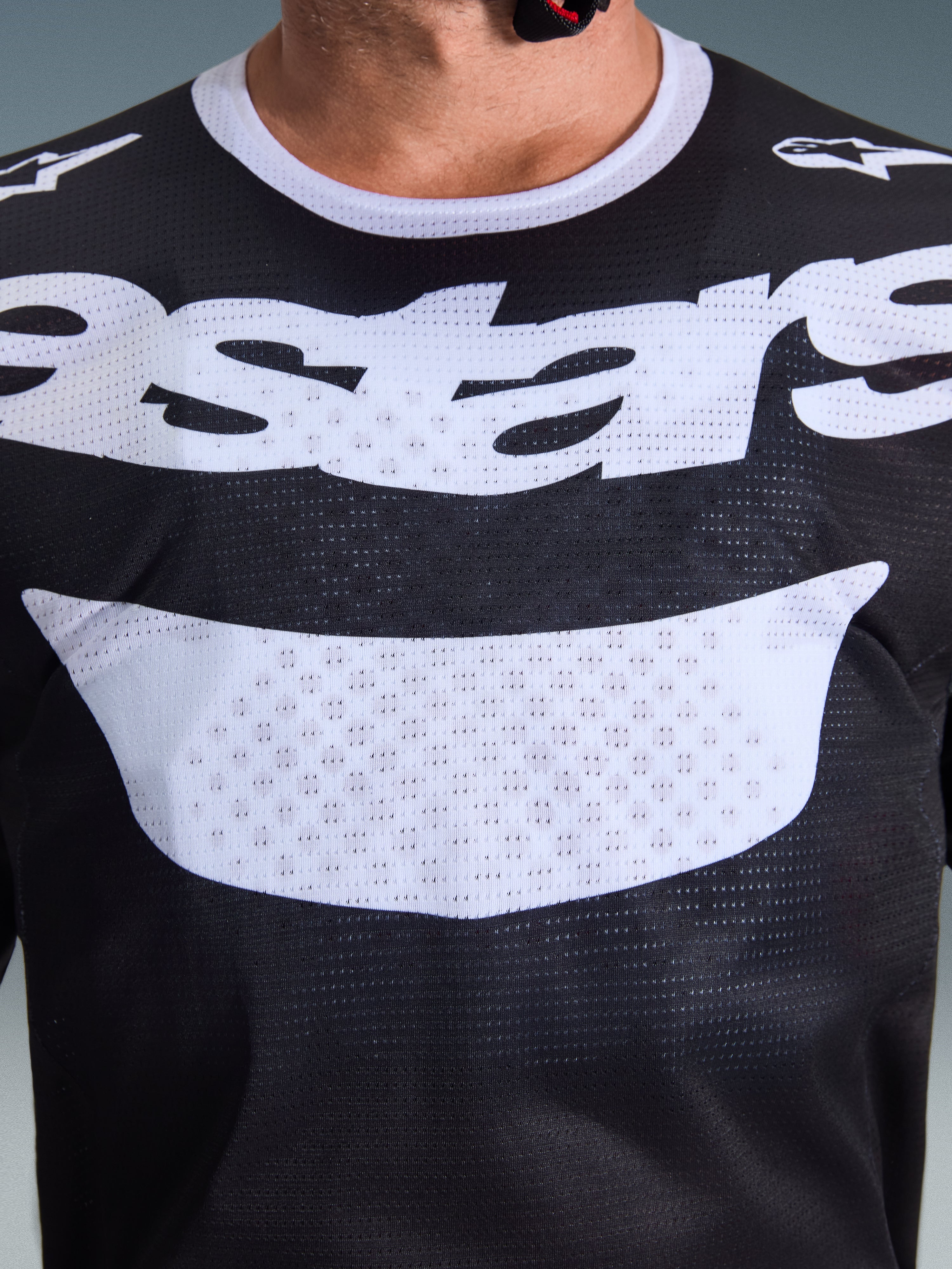 Alpinestars 2026 Racer Air Riway-tröja, motocrosströja, svart och vit, närbild av bröstet med stor vit logotyp, detaljerad meshtextur för luftflöde, teknisk utrustning med andasfunktion för terrängkörning