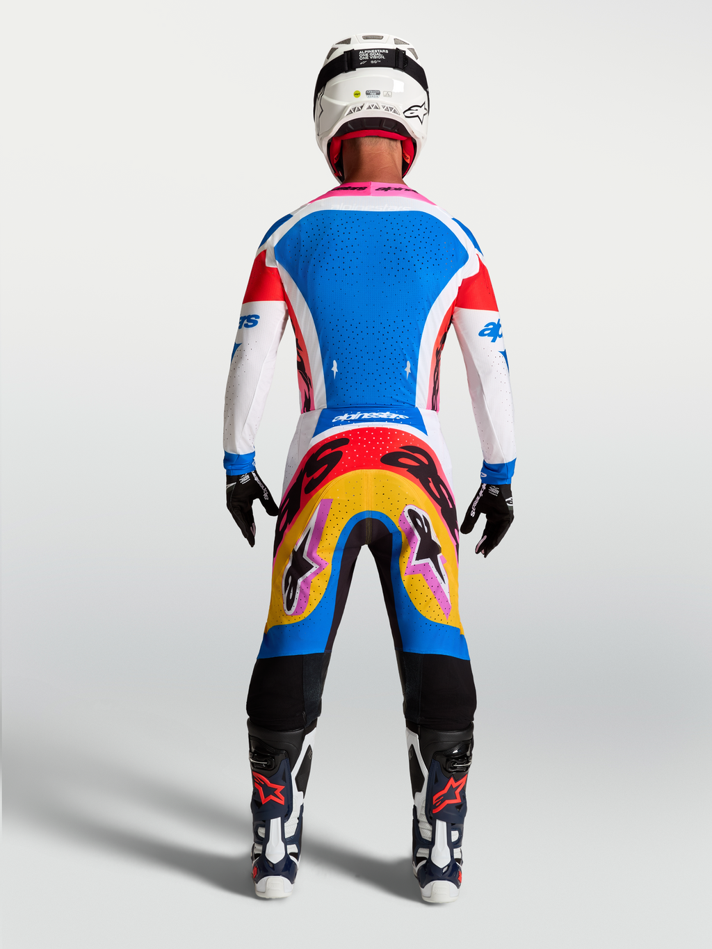 Alpinestars Supertech Dyna tröja och utrustningsset, blå och vit motocrossutrustning, vy bakifrån på modell med rosa detaljer.
