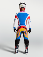 Alpinestars Supertech Dyna tröja och utrustningsset, blå och vit motocrossutrustning, vy bakifrån på modell med rosa detaljer.
