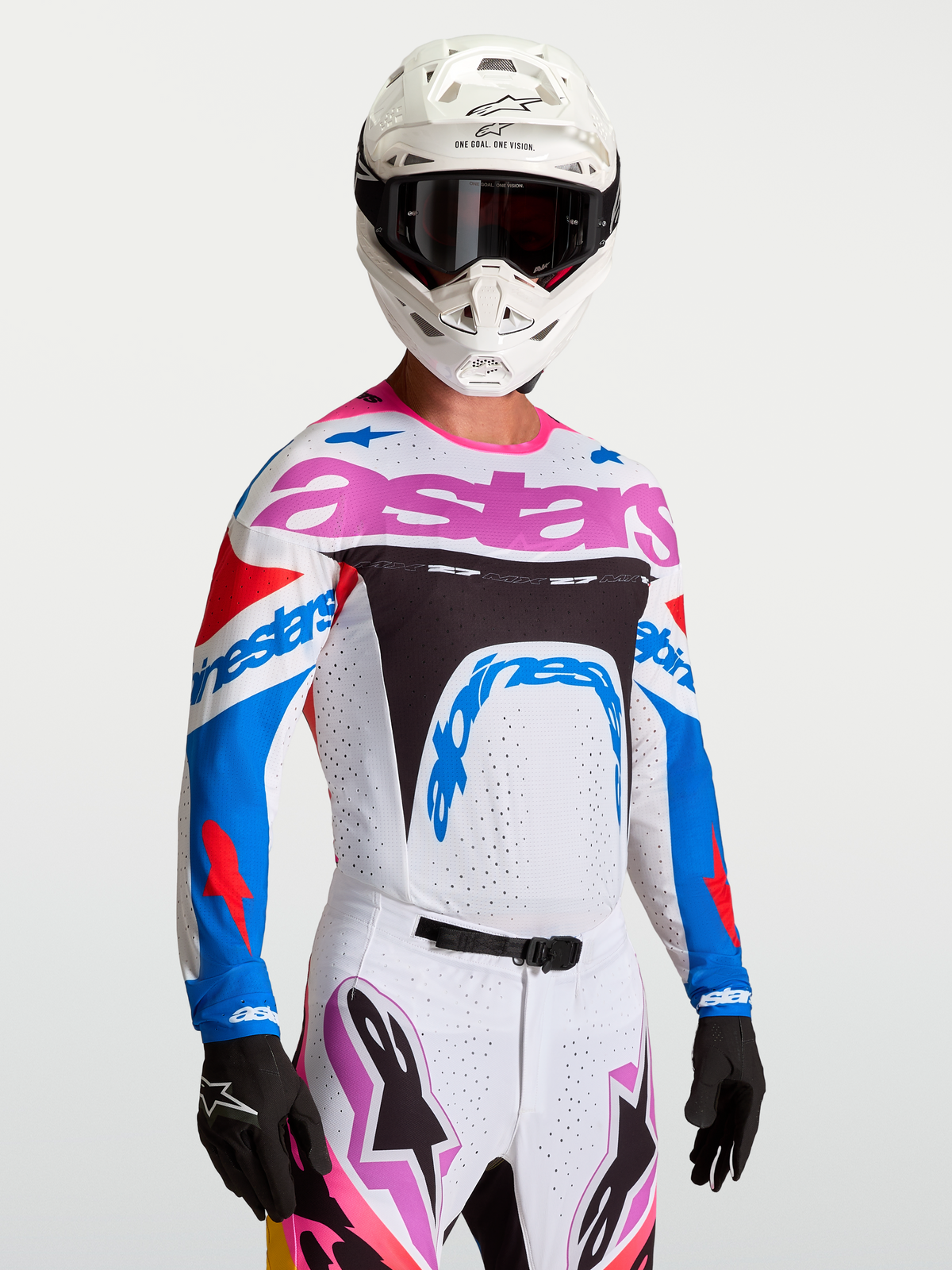 Alpinestars Supertech Dyna tröja, motocrosströja i vitt och blått med lila accenter, atletisk stretchmesh, bärs av modell med hjälm och handskar, professionell utrustning för terrängkörning