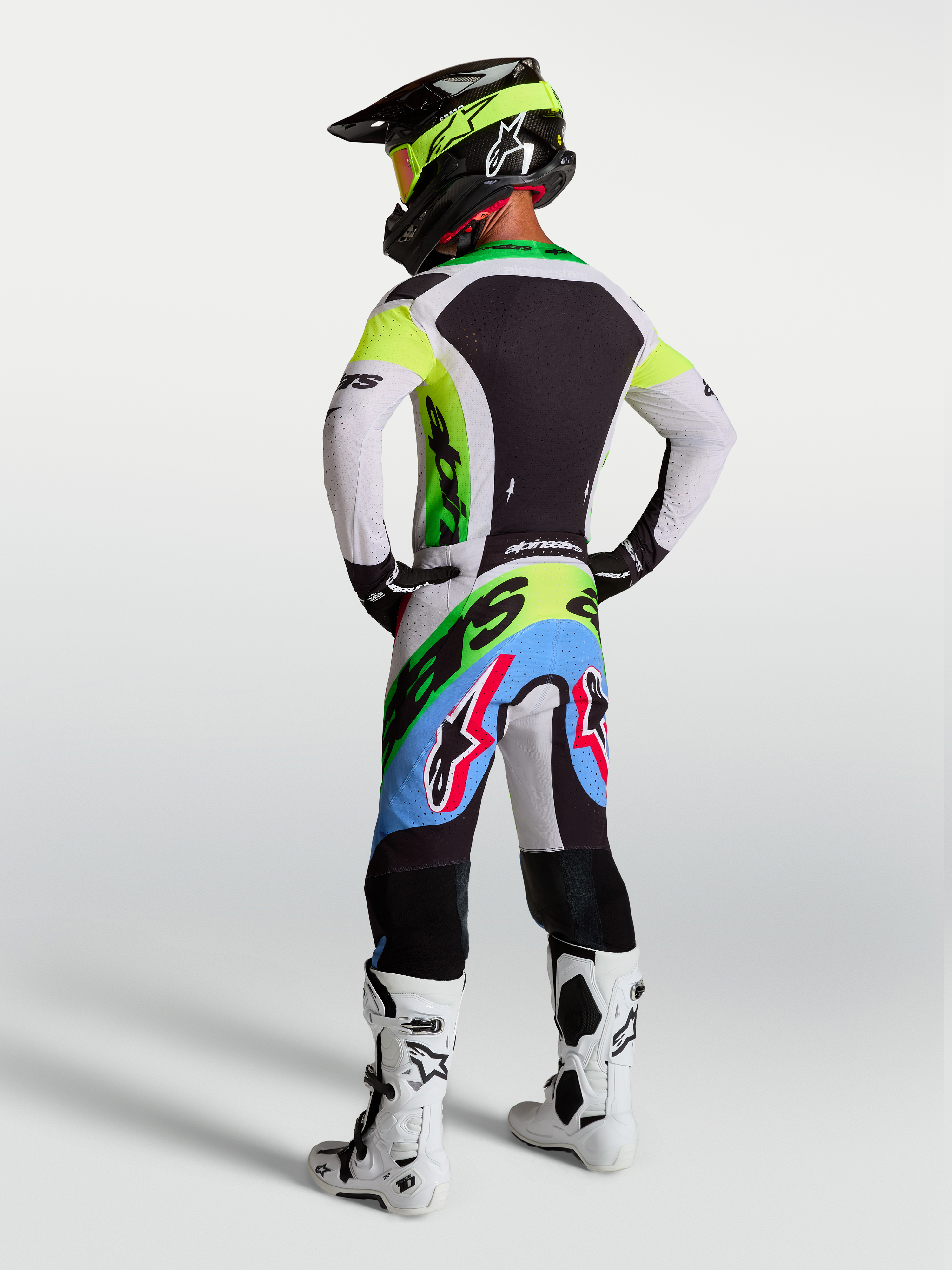 Alpinestars Supertech Dyna tröja och gear set, motocrossutrustning för herrar i neongrönt och lila, vy bakifrån med atletisk racingpassform och andningsbar stretchmesh.