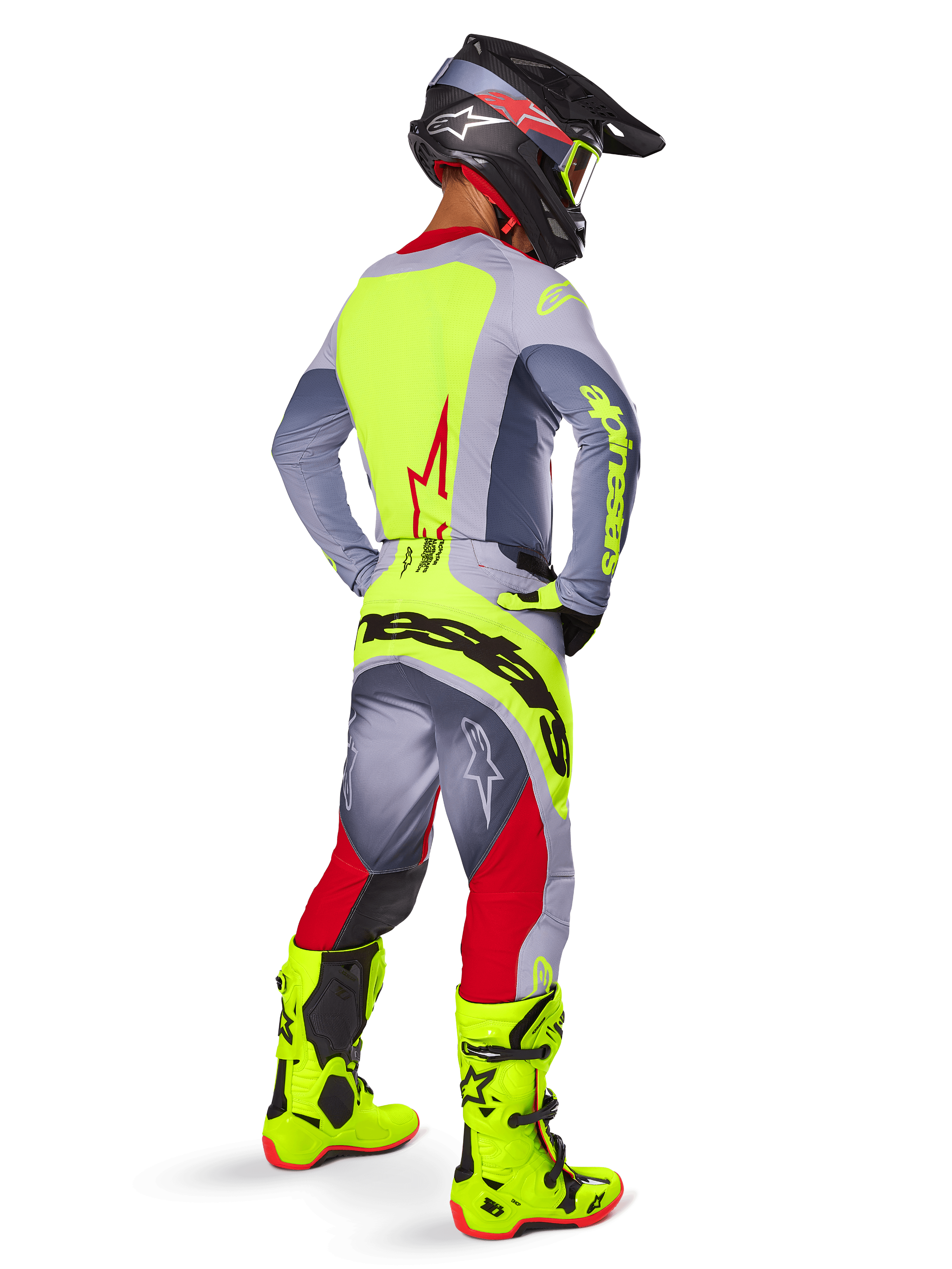 Motocrossförare sedd bakifrån iklädd Alpinestars 2025 Techstar Melt-tröja i Bright Red Gray, med en klargul ryggpanel och grå ärmar, matchande grå och röda byxor med gul logotyp, klargula motocross-stövlar och en svart hjälm med gula goggles, koordinerad racingutrustning för terrängkörning