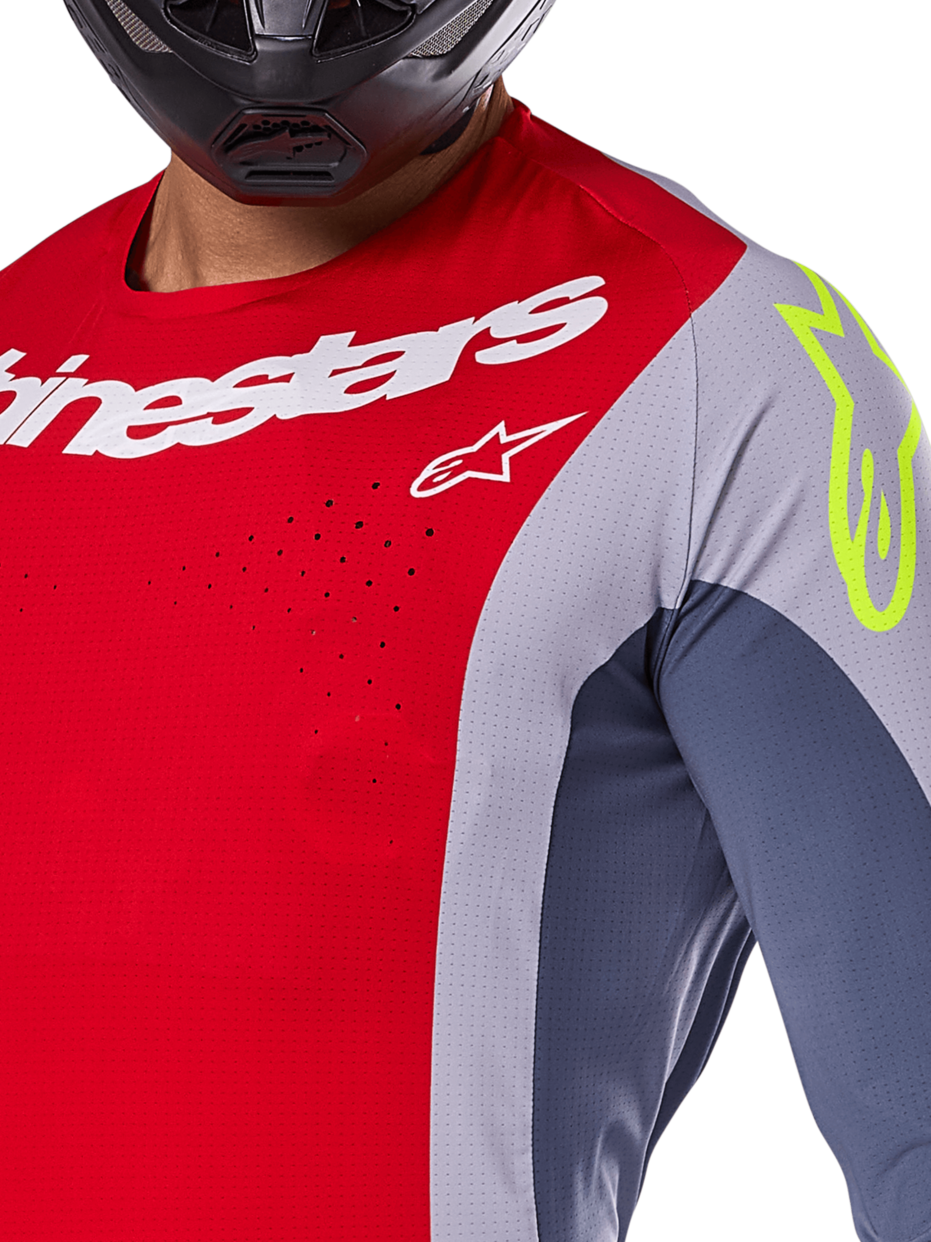 Alpinestars 2025 Techstar Melt Jersey, motocrosströja, klar röd och grå med mörkblå paneler, med vit Alpinestars-logotyp och en neongul logotyp på axeln, närbild som visar laserskurna ventilationsperforeringar och en svart hjälm.