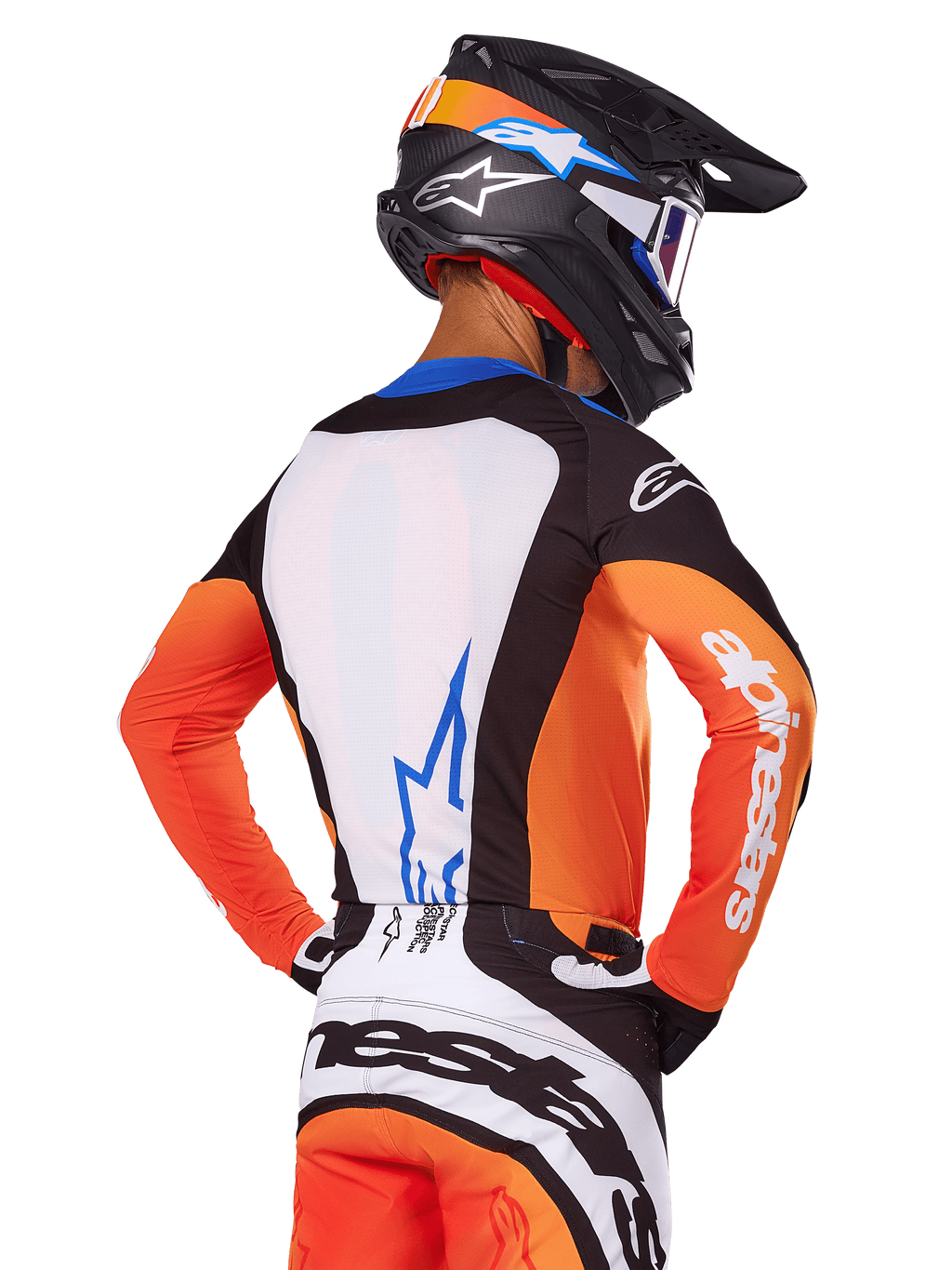 Motocrossförare i Alpinestars 2025 Techstar Melt Jersey, orange och blå, vy bakifrån som visar vit ryggpanel med blå logotyp, orangea ärmar med vit logotyp, matchande motocrosshjälm och byxor, professionell racingutrustning.