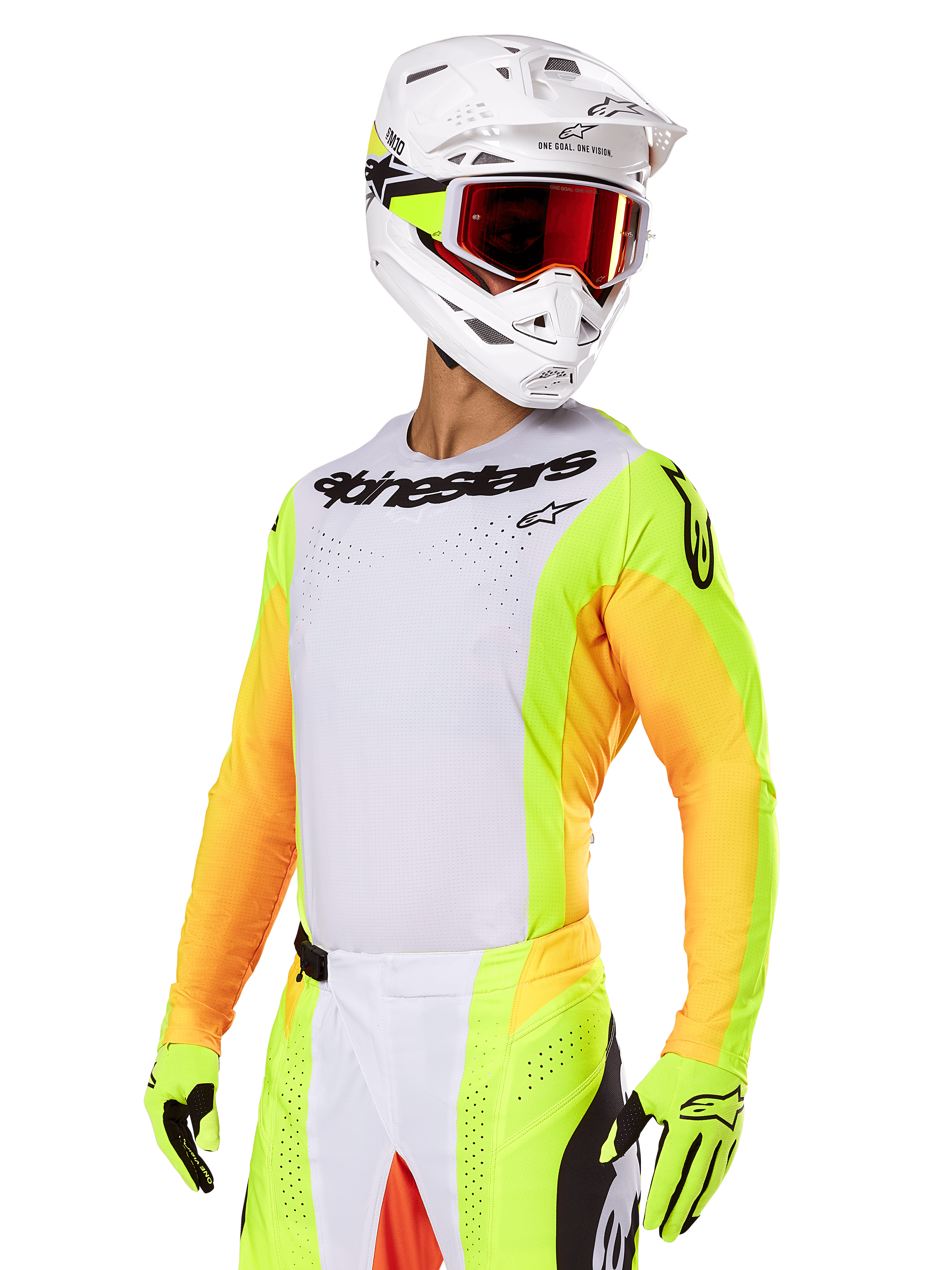 Motocrossförare klädd i Alpinestars 2025 Techstar Melt-utrustningsset, vit tröja med färgstarka gula och orangea ärmar, svart Alpinestars-logotyp på bröstet, matchande neongula handskar, vit hjälm med rödfärgade goggles, professionellt racingställ för terrängkörning