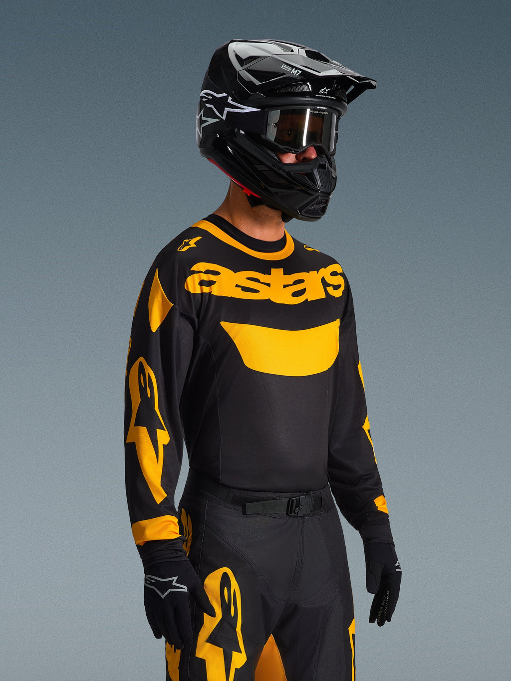2026 Racer Riway Gear Set, motocrossförare i svart tröja med gul 'astars'-logotyp och gula detaljer på ärmarna, matchande svarta och gula byxor, svart hjälm med goggles och svarta handskar, koordinerad racingoutfit för terrängkörning