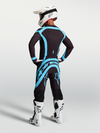 Alpinestars Supertech Vesta tröja och utrustningsset för herrar, svart och turkos motocrossutrustning sedd bakifrån.