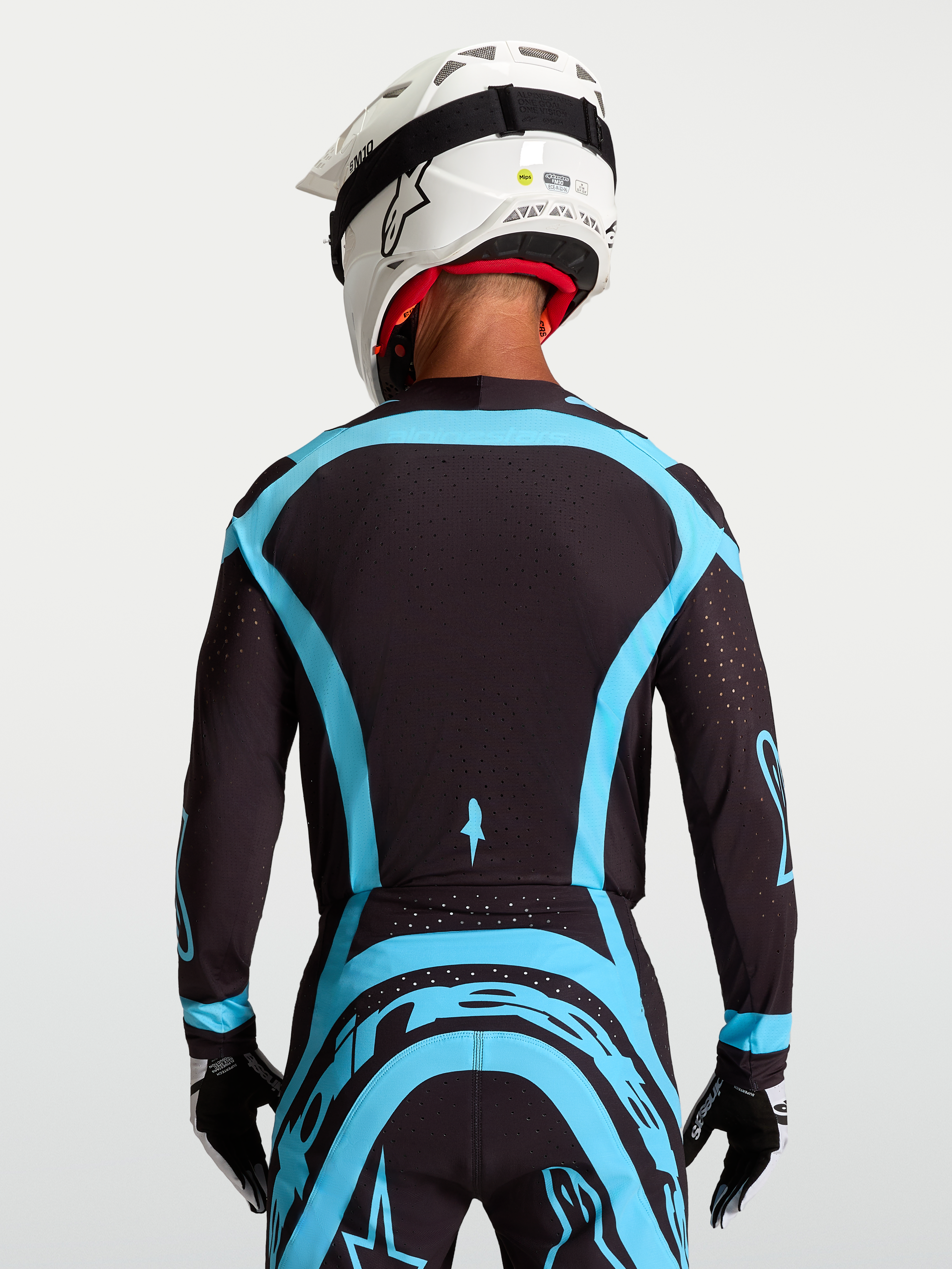 Alpinestars Supertech Vesta tröja, svart och turkos pro-level motocrosströja med stretchmesh, ryggvy på modell.