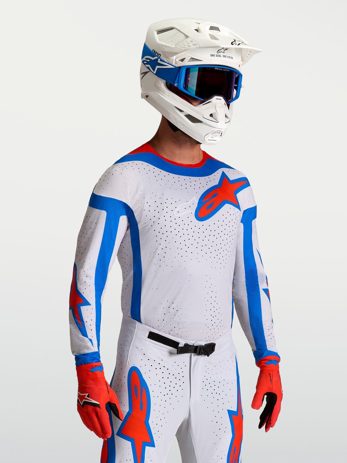 Alpinestars Supertech Vesta tröja, motocrosströja för racing, vit, röd och blå, atletisk passform i stretchmesh, bärs av modell med matchande utrustning för terrängkörning