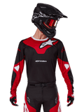 Alpinestars 2025 Racer Veil Jersey, Motocross Jersey, Black and Bright Red, worn with matching pants, black helmet, and red goggles, featuring bold white logos and a sleek racing design, performance gear for off-road motocross