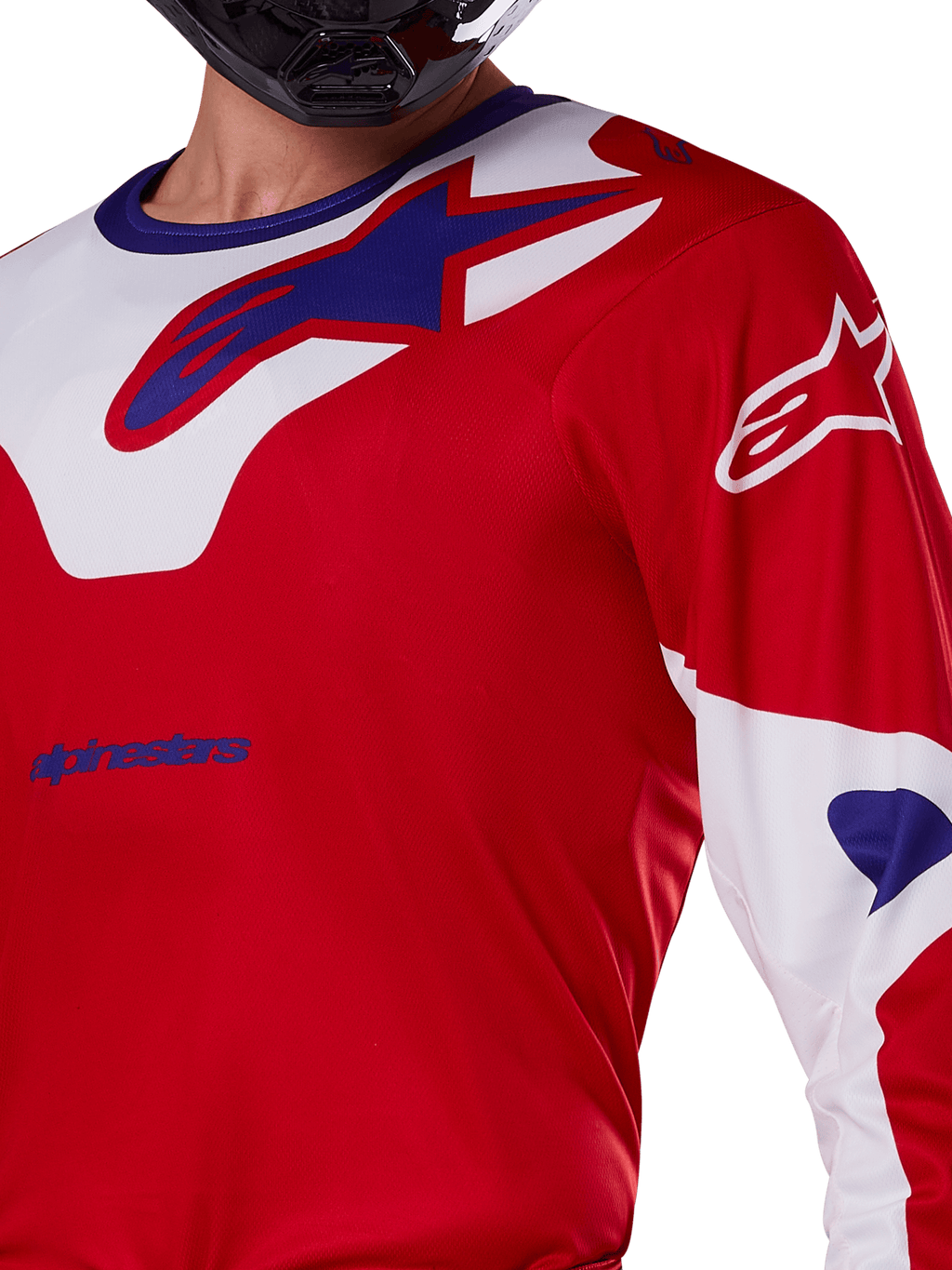 Alpinestars 2025 Racer Veil tröja, motocrosströja, klar röd och vit, närbild av överkropp och bröst, blå Alpinestars-logotyp på en vit kragpanel, röda ärmar med vita detaljer, bärs med en svart hjälm, tekniska kläder för terrängkörning