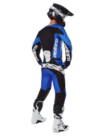Motocross rider wearing complete racing gear seen from behind, 2025 Racer Veil Jersey and matching pants in Blue and Black, featuring white Alpinestars branding, black helmet, white and black boots, coordinated outfit for off-road racing