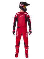 Alpinestars 2025 Fluid Haul Gear Set, Motocross racing outfit in Bright Red and Black, featuring a red jersey with black sleeves and white branding, matching red pants with white star logos, black helmet with gold-tinted goggles, and red boots, complete gear for off-road riding