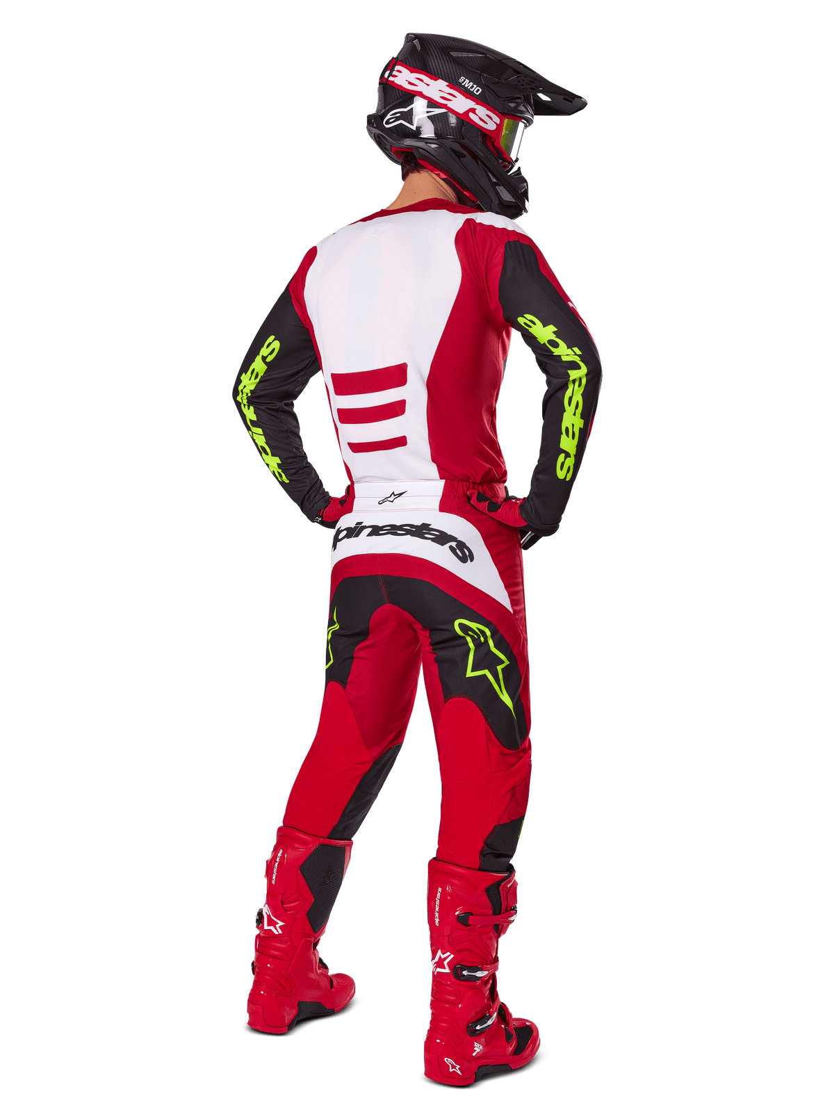 Motocross rider from behind wearing the Alpinestars 2025 Fluid Haul Gear Set, Bright Red and Black with white panels, neon yellow branding on sleeves and pants, matching red boots and black helmet, complete professional off-road racing gear.