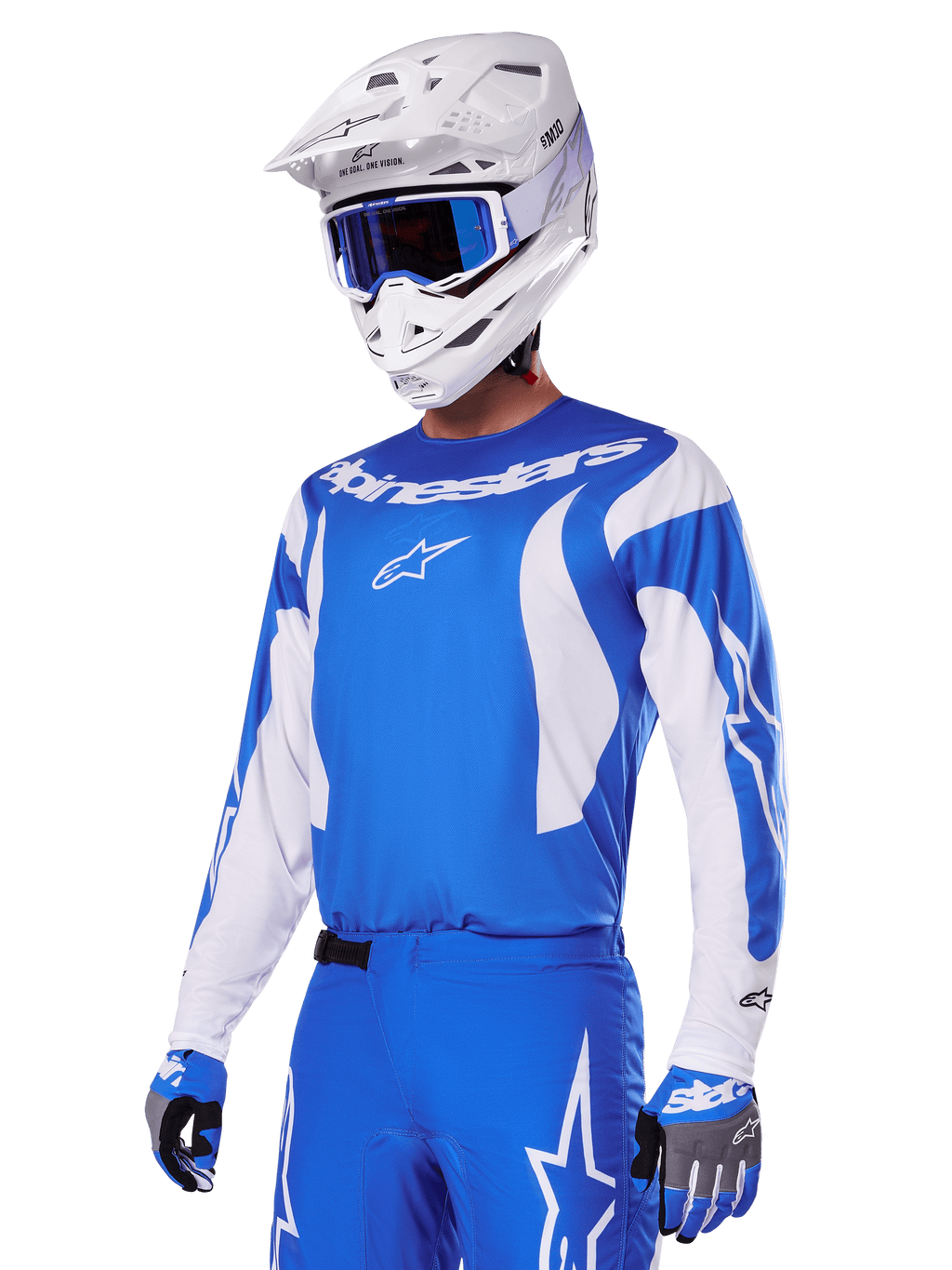 Motocrossförare som bär Alpinestars 2025 Fluid Haul utrustningsset i blått och vitt, blå tröja med vita detaljer, matchande blå byxor med stjärnlogotyper, vit hjälm med blå goggles, koordinerade blå och grå handskar, komplett racingoutfit för terrängkörning