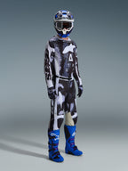 Alpinestars 2026 Racer Lahnd Gear Set, motocross rider wearing a black and white patterned jersey and pants with an abstract weathered design, featuring large white Alpinestars branding, paired with vibrant blue and purple boots and a blue and white helmet, complete professional off-road racing outfit.