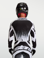 Alpinestars Techstar Swan motocrosströja, herr, svart och vit, vy bakifrån med tävlingspassform och grafiska detaljer.