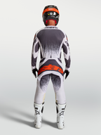 Alpinestars Techstar Swan tröja och utrustningsset, grå och vit motocrossutrustning med röd logotyp, vy bakifrån på modell.
