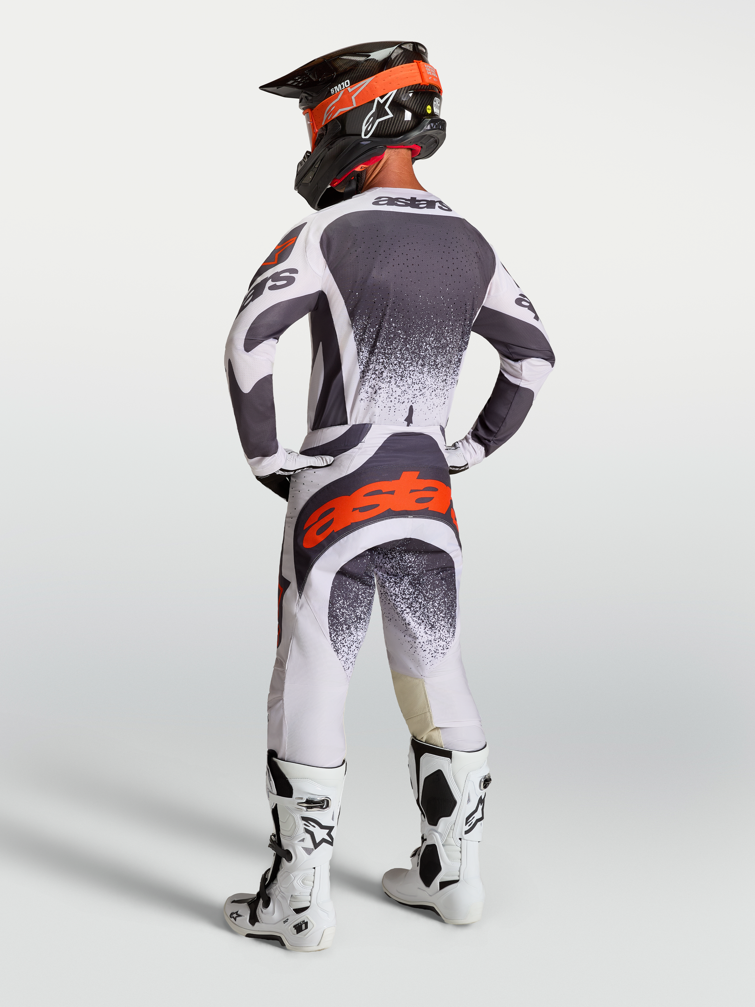 Alpinestars Techstar Swan tröja och gear set, motocrossutrustning för herr i mörkgrått och röd fluo, sedd bakifrån.