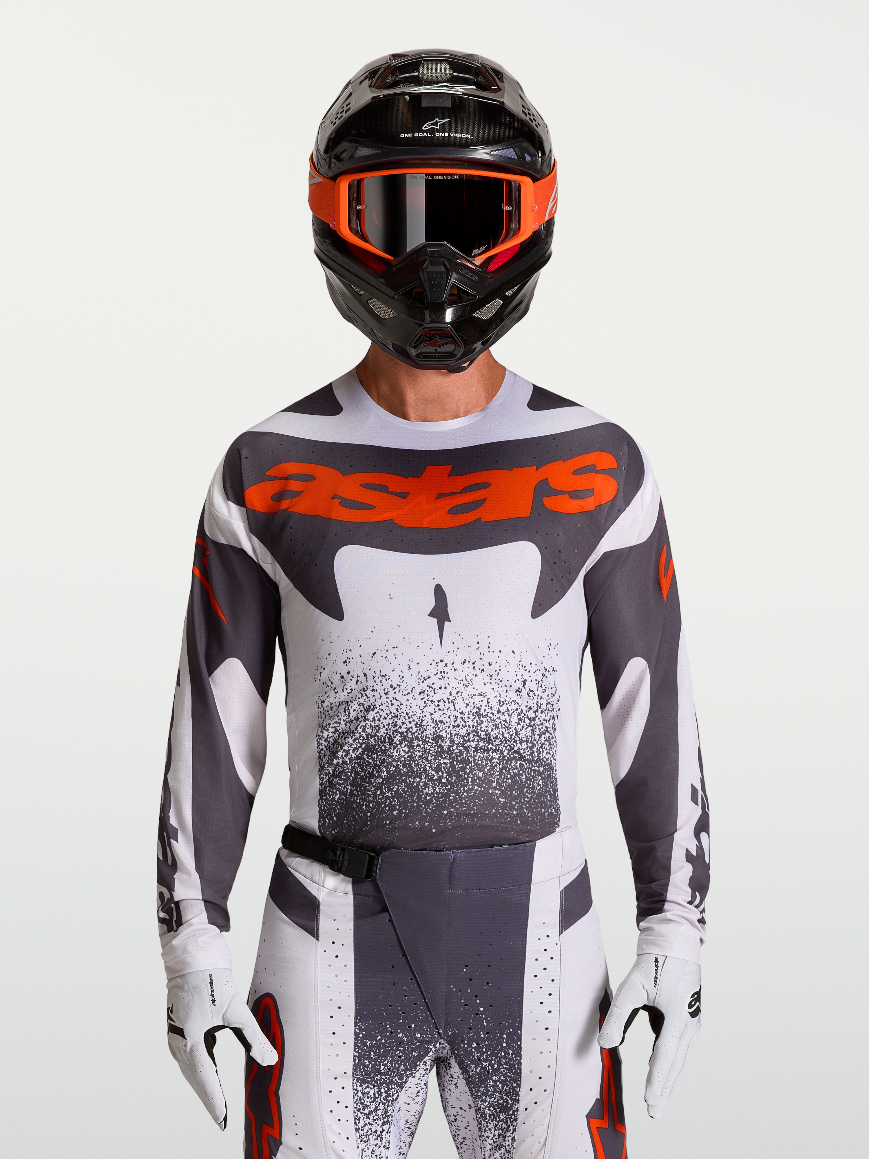 Alpinestars Techstar Swan tröja, motocrosströja för herrar i vit och grå med röd fluo, atletisk racingpassform och laserperforeringar för ventilation, visas på modell med matchande utrustning.