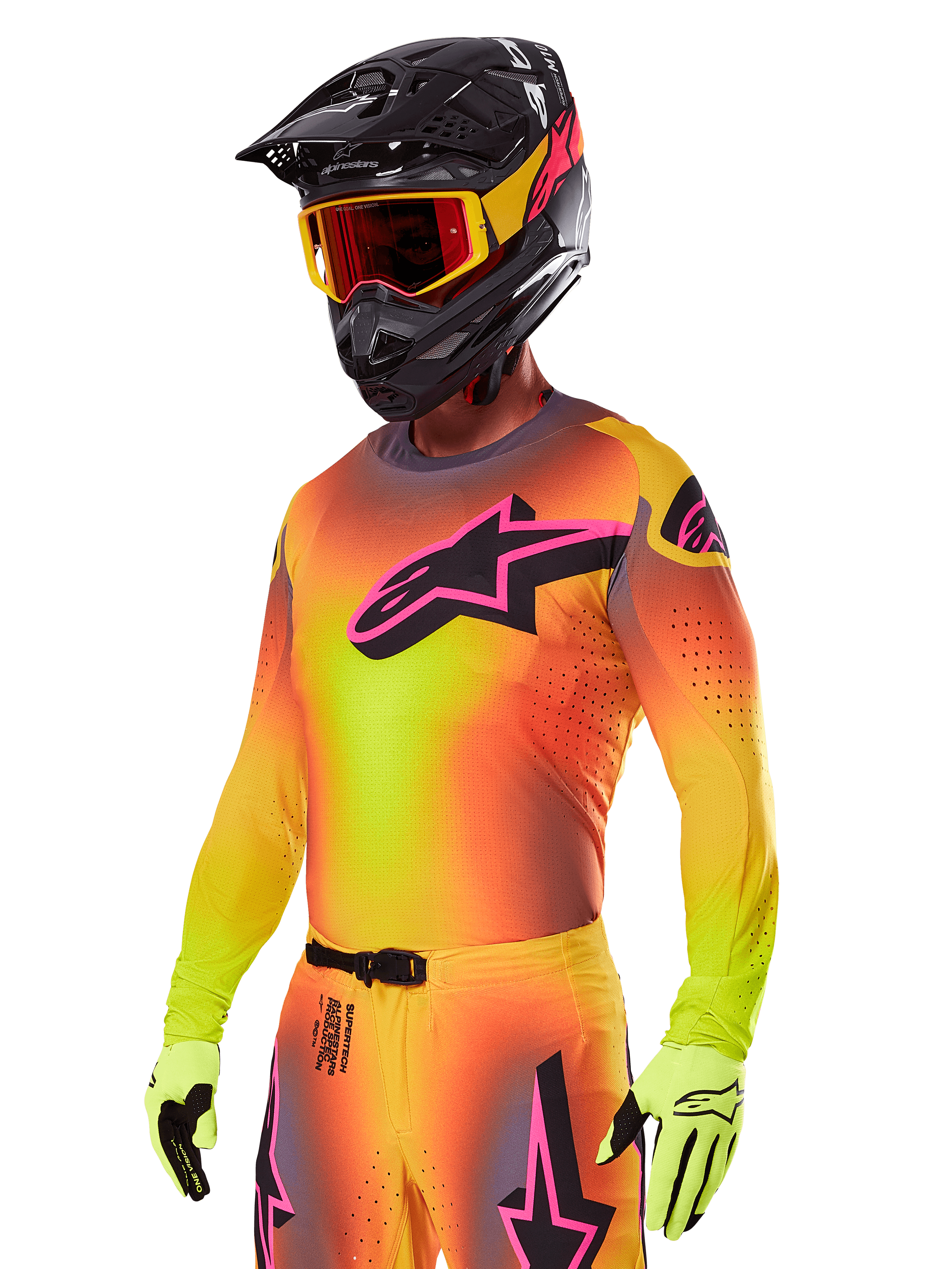 Motocrossförare i Alpinestars 2025 Supertech Lipan utrustningsset, gul och orange tröja med färgövergång, rosa och svart Astars-logotyp, neongula handskar, svart hjälm med röda goggles, professionell utrustning för terrängkörning
