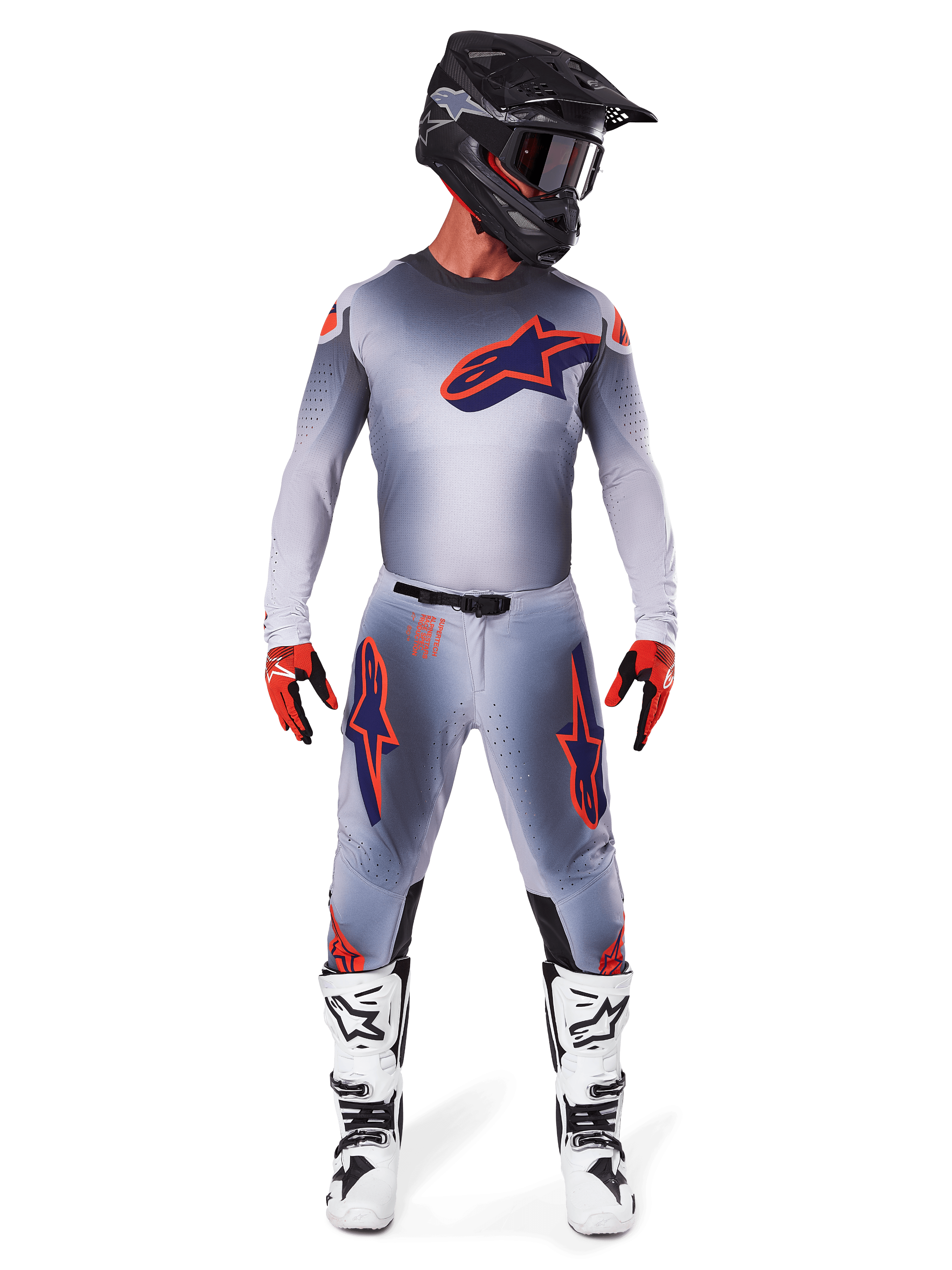 Motocross rider wearing the Alpinestars 2025 Supertech Lipan Jersey in Gray Orange Fluo, featuring a gray gradient design and orange logo, paired with matching motocross pants, black helmet, white boots, and orange gloves, coordinated pro-level racing gear.