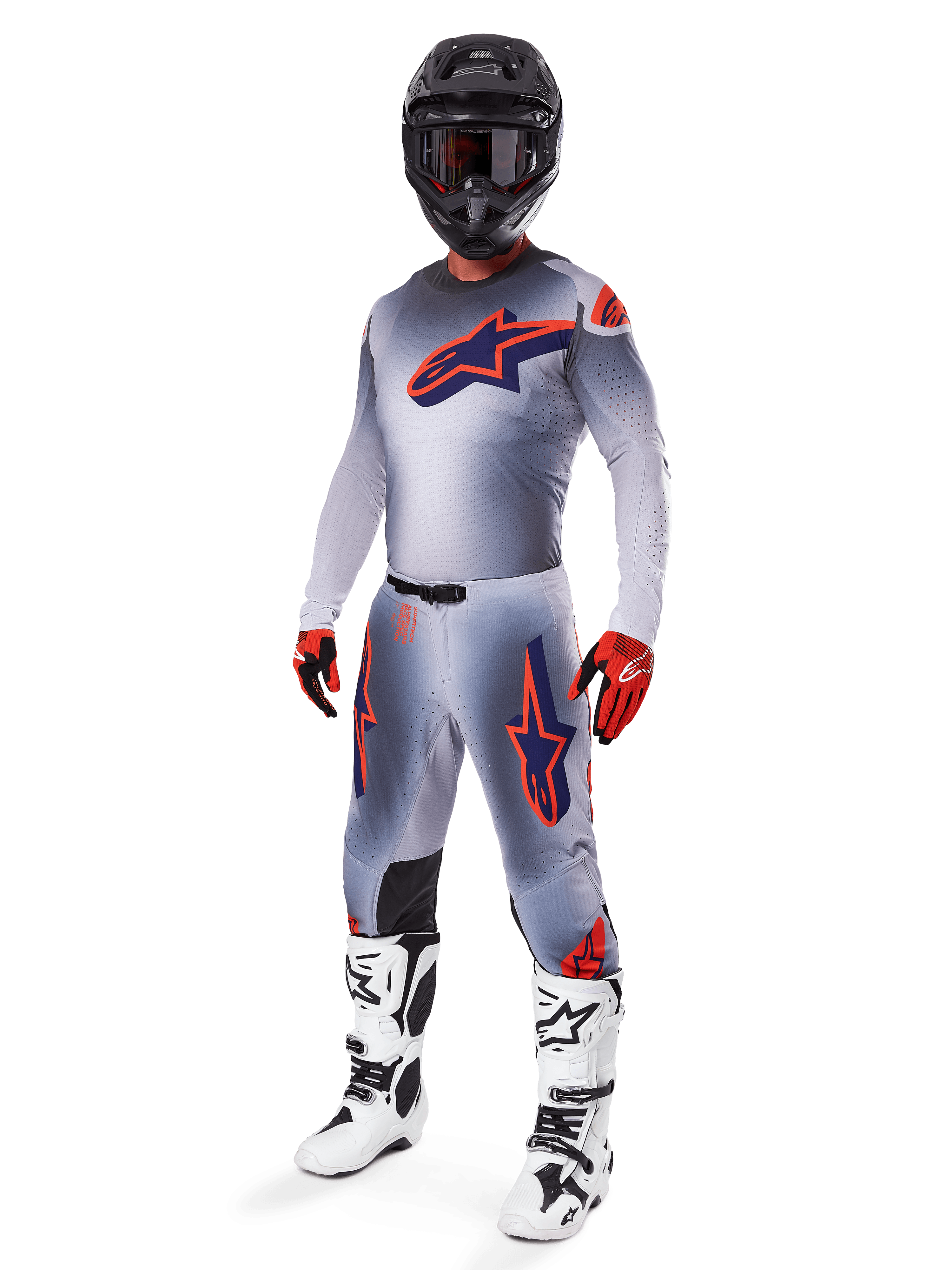 Alpinestars 2025 Supertech Lipan utrustningsset, motocrossutrustning, grå med stjärngrafik i fluorescerande orange och mörkblått, bärs med svart hjälm, röda och svarta handskar samt vita och svarta stövlar, komplett professionell offroad-outfit med ventilerad design