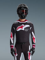 Alpinestars 2026 Supertech AFD Vista Jersey, Motocross Jersey in Black Red and White, shown on a rider with a black helmet, goggles, and gloves, featuring a large chest logo and 'SUPERTECH AFD' branding, professional racing gear for off-road performance