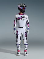 Motocrossförare i komplett 2026 Supertech AFD Vista-utrustningsset, vit tröja och byxor med lila, rosa och svarta detaljer, svart hjälm med lila logotyp och blå goggles, vita stövlar med rosa detaljer, koordinerad professionell racingoutfit för terrängkörning