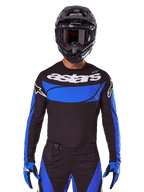 Alpinestars 2025 Techstar Dreem-set och tröja, svart och blå motocrossutrustning bärs av en förare för terrängkörning.