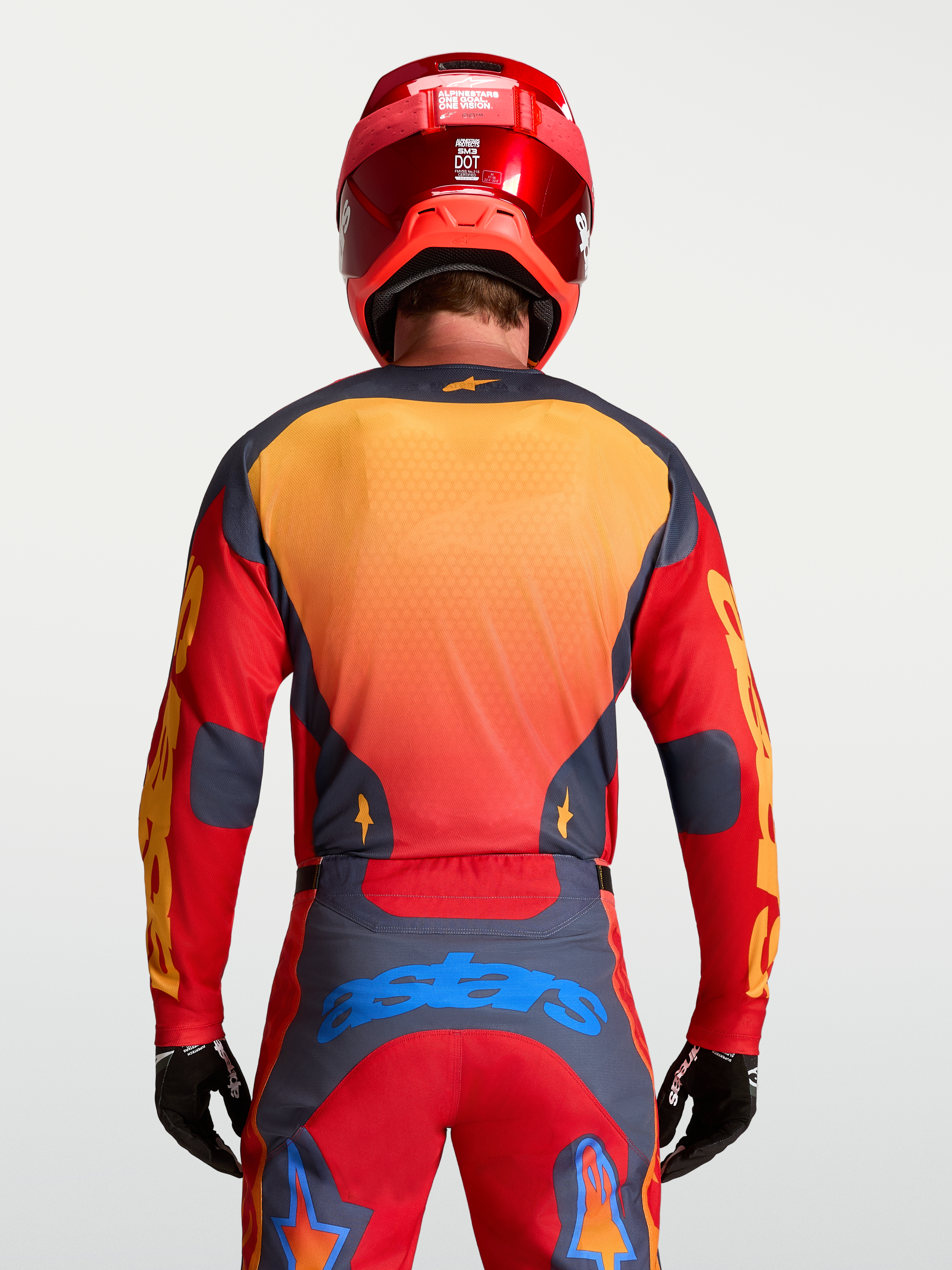 Alpinestars Racer Hunt tröja, MX-utrustning för herr, röd och grå med gula detaljer, sedd bakifrån på modell, lätt och ventilerat material för motocross.