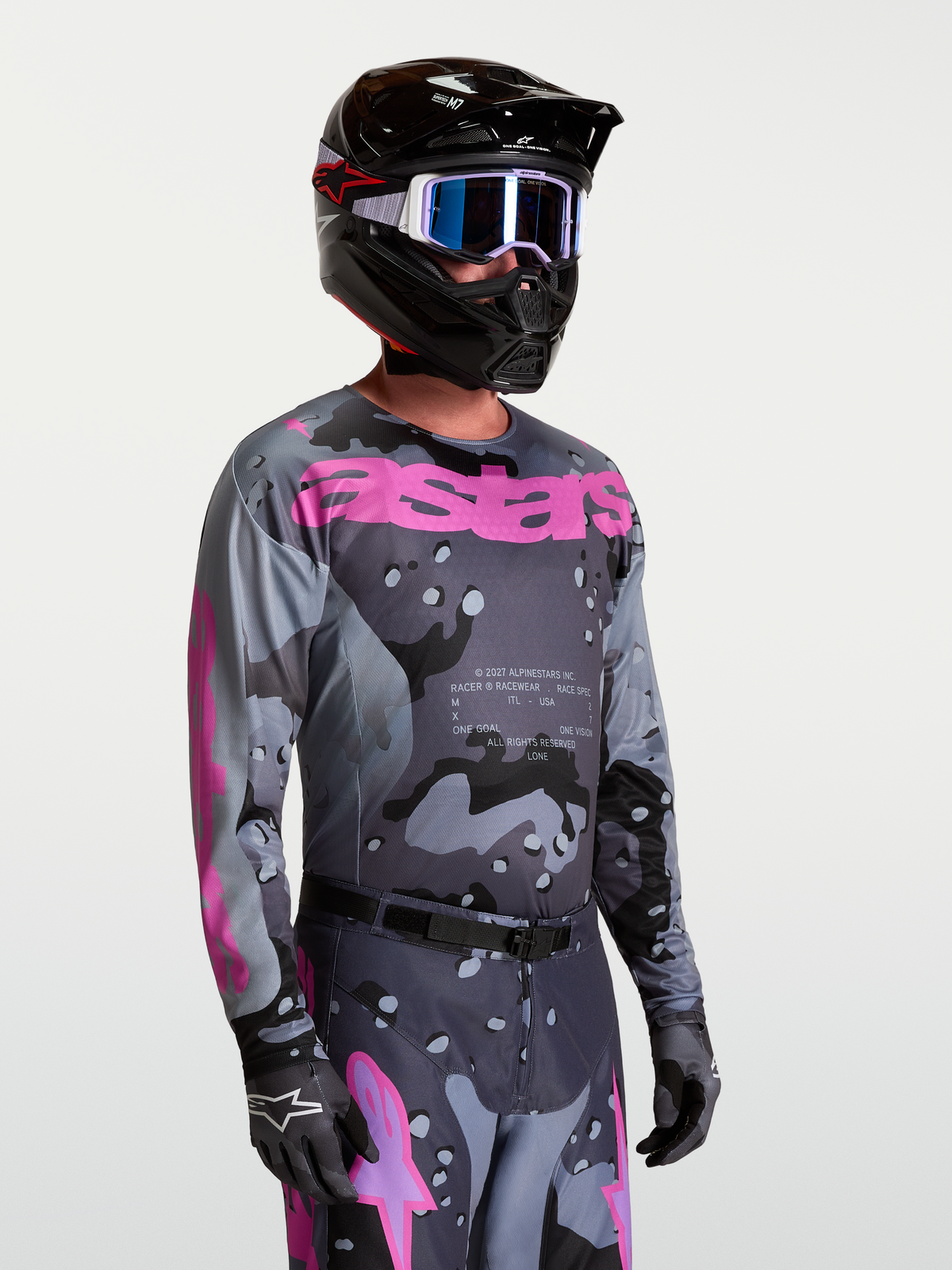 Alpinestars Racer Lone tröja, motocrosströja för herr, grå camo och lila, bärs av modell med fullständig MX-utrustning och hjälm.