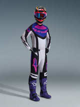 Motocrossförare bär Alpinestars 2026 Techstar Knif Jersey i Black Light Gray Purple, matchande byxor med stora rosa logotyper, lila stövlar och flerfärgad hjälm med blå goggles, komplett racingutrustning för terrängprestanda