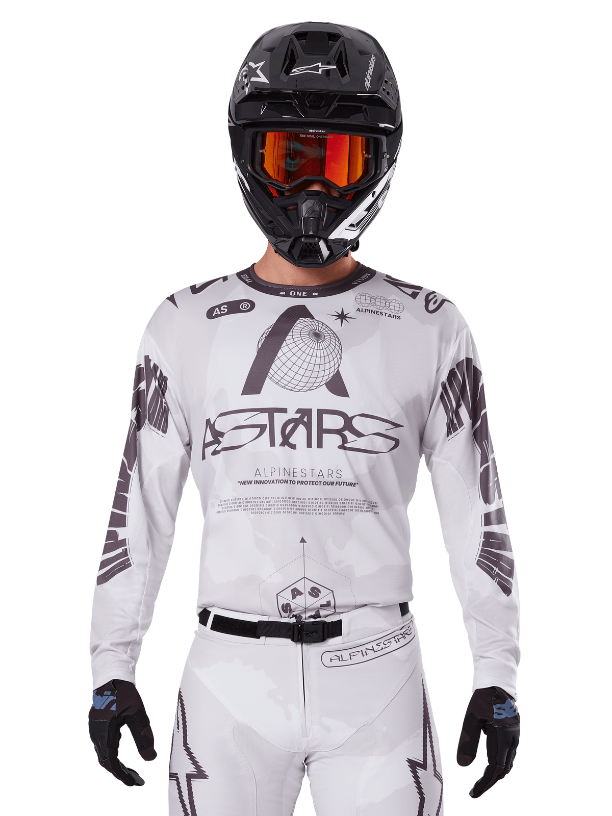 Alpinestars 2025 Racer Hollow tröja, motocrosströja, vit och svart, bärs med matchande vita MX-byxor och en svart hjälm med orangea goggles, med framträdande Alpinestars-logotyper och jordglobgrafik, professionell utrustning för terrängkörning